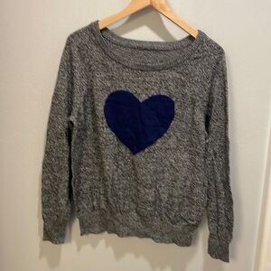 Woman’s grey sweater with a blue heart